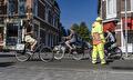 Verkeersregelaar begeleidt fietsers langs een werkvak