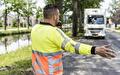 Verkeersregelaar in signaalkleding regelt het verkeer