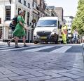 Voetgangers steken over bij een bus van Traffic Base
